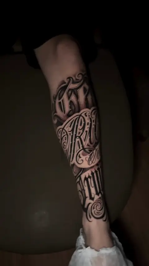 Perna com a frase Get rich or die trying em lettering com floreios