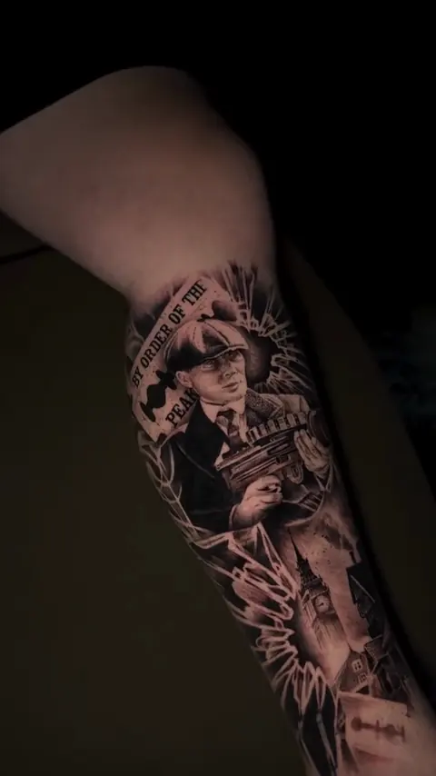 Thomas Shelby de Peaky Blinders com metralhadora, em preto e cinza